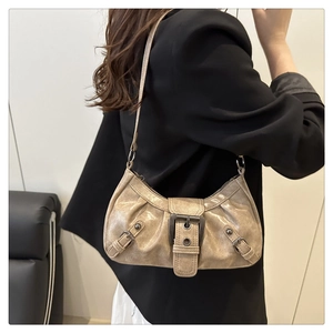 Close-up of champagne gold metallic underarm bag with decorative vintage buckles