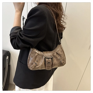 Detail of vintage brown oil wax leather shoulder bag with metallic buckle accent