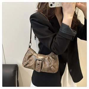 Side view of vintage brown shoulder bag with buckle details on a female model