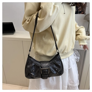 Detail view of vintage black shoulder bag with distressed leather texture and metal buckle