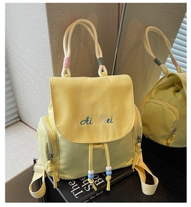Detail of yellow nylon backpack with Ai Mei embroidery and colorful beaded accents