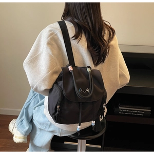 Dettaglio dello zaino nero in nylon con ricamo Ai M e coulisse decorate con perline