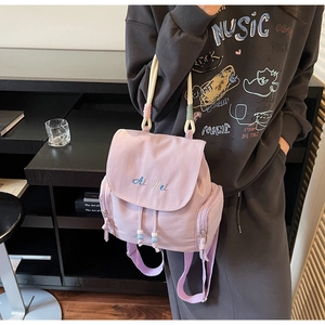 Dettaglio dello zaino in nylon lavanda con chiusura a coulisse e tasche laterali