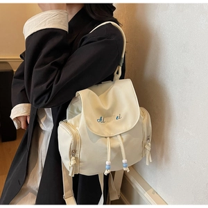 Dettaglio dello zaino bianco panna con chiusura a coulisse e ricamo blu Ai Mei