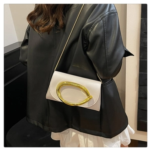 Détail du sac bandoulière en cuir blanc avec grand fermoir ovale doré et chaîne fine