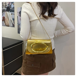Détail du sac à main doré métallisé avec grande boucle ovale et bandoulière chaîne