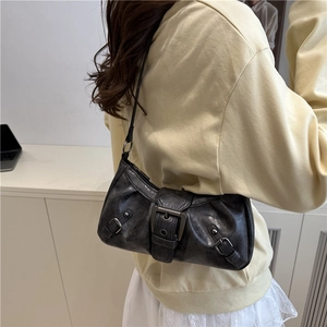 Retro black faux leather shoulder bag with buckle details shown on model's shoulder