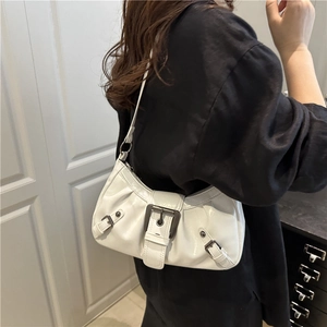 Vintage white glossy underarm shoulder bag with metal buckle on woman in casual setting