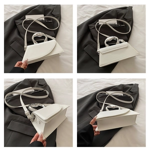 Viste multi-angolo di una borsa a trapezio in pelle bianca con manico a cuore argento