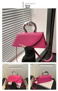 Dettaglio borsa trapezoidale rosso rosa con manico metallico argento e pelle opaca rifinita