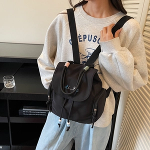 Fashionable black nylon backpack for women featuring drawstring closure and side pockets