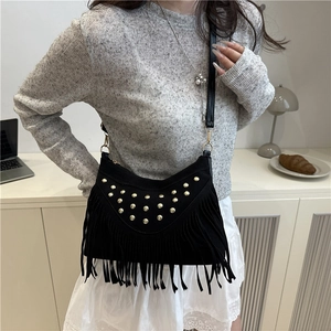 Retro black fringe hobo bag with gold rivets and matte finish worn by model
