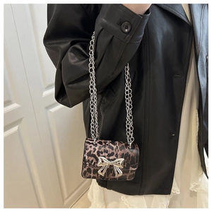 Détail d'un mini sac bandoulière léopard avec nœud en métal argenté et bandoulière