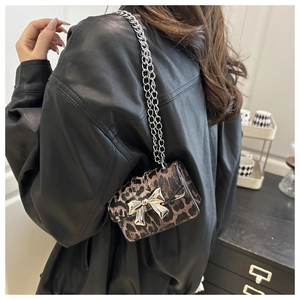 Détail du mini sac bandoulière léopard avec boucle noeud argentée et bandoulière chaîne