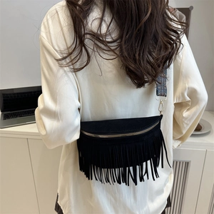 Sac bandoulière vintage à franges noires avec large sangle porté par un mannequin