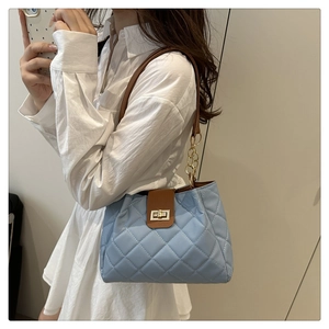 Détail du sac fourre-tout matelassé bleu clair avec chaîne dorée et fermoir métal