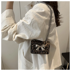 Détail du mini sac carré léopard avec nœud en métal argenté et bandoulière chaîne