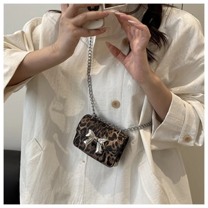 Détail du mini sac léopard avec nœud argenté et fine bandoulière en chaîne