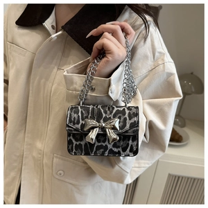 Détail du mini sac en cuir léopard avec nœud argenté et bandoulière en chaîne