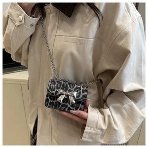 Détail d'un mini sac bandoulière léopard avec boucle nœud argenté et chaîne métal
