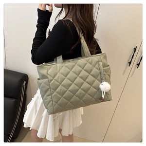 Quilted tote bag in olive green with side pocket and fluffy charm on shoulder view