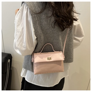 Pink leather handbag with embossed texture shown being worn as a crossbody bag