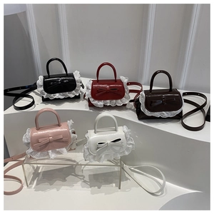 Detailed view of mini bow bags with lace trim in five colors on a tiered display