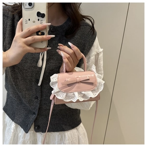Dettaglio della mini borsa rosa con bordo in pizzo bianco e decorazione a fiocco