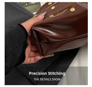 Gros plan détaillé des coutures et rivets dorés sur le sac en cuir brillant marron foncé
