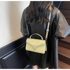 Détail du sac à main vert menthe en similicuir avec bandoulière réglable et bouton-pression