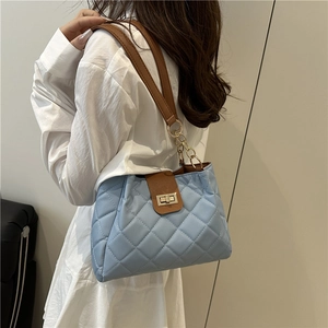 Sac cabas bleu clair matelassé avec anses en cuir marron et détails de chaîne dorée