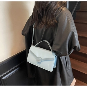 Vue portée d'un petit sac bleu clair en daim avec rabat et bandoulière réglable