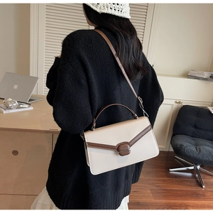 Photo lifestyle montrant le porté épaule du sac carré bicolore crème et marron élégant