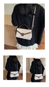 Detail view of contrast color faux suede crossbody bag with vintage brown curved handle