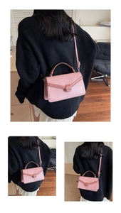 Detail of pink contrast flap bag showing trapezoid shape and metallic buckle clasp
