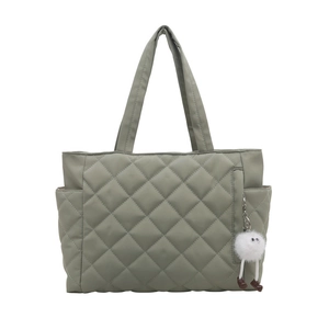 Quilted sage green tote bag with diamond pattern and cute plush monster keychain charm