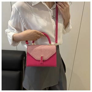 Detail of fuchsia checkered crossbody bag with adjustable strap worn by a model