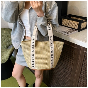 Detail of woven straw tote bag with Summer & Beauty printed canvas straps for beach style