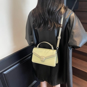 Sac bandoulière tendance en daim vert clair avec boucle métallique sur un mannequin