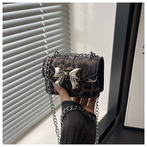 Detail of silver bow buckle and leopard print pattern on women chain shoulder bag