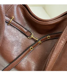 Detail of vintage brown lychee grain leather texture and brass-tone metal buckle