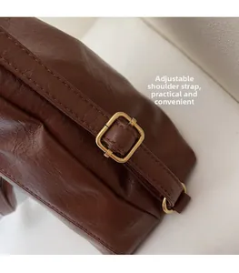 Detail of dark brown leather strap with adjustable gold buckle and precise stitching