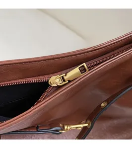 Detailed macro view of smooth golden zipper and premium brown leather texture on backpack