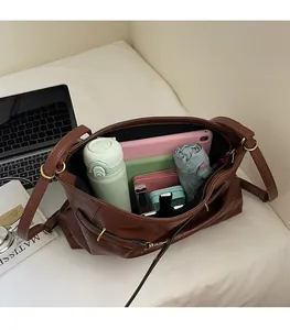 Detail view of spacious brown tote bag interior filled with daily essentials for work