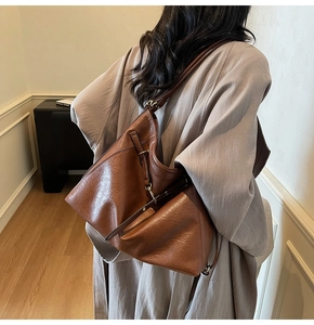 Detail showing the large brown hobo bag with vintage leather texture and buckle