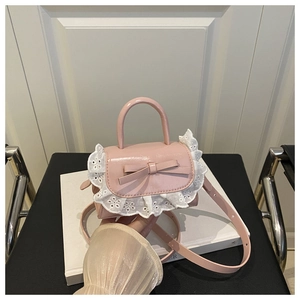 Close-up of pink patent leather bag with white lace trim and bow accent detail