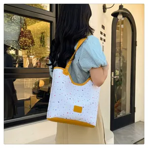 Canvas tote bag with colorful splash pattern and bright yellow leather strap detail