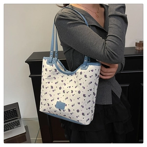 Close-up of floral tote bag with blue trim and Fashion Bags leather label detail