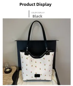 Detailed view of white floral canvas bucket bag with black handles and leather logo