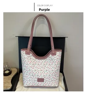 Detailed view of floral tote bag with purple faux leather trim and silver rivets decoration